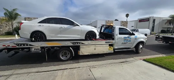 Fast Hook Towing flatbed transporting a Cadillac sedan