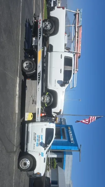 Fast Hook Towing flatbed towing a Chevy Silverado 2500 work truck