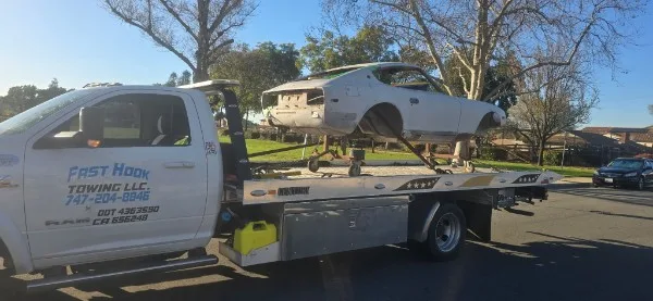 Fast Hook Towing flatbed towing a bare-metal classic car restoration project