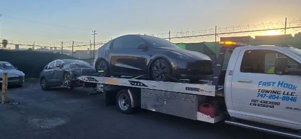 Fast Hook Towing flatbed towing a Tesla Model Y at sunset