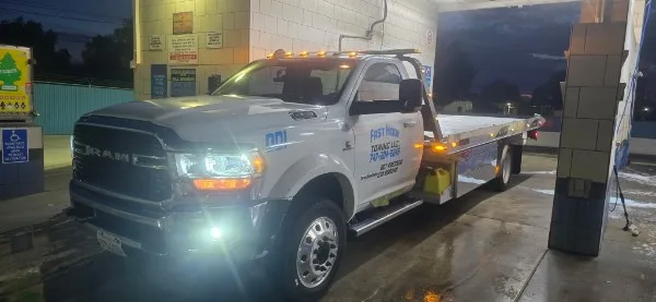 Fast Hook Towing flatbed tow truck at night — 24/7 towing service