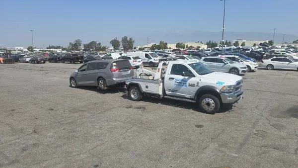 Fast Hook Towing wheel-lift towing a minivan — wide shot
